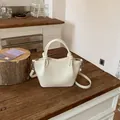 Elegant cream white textured bucket bag featuring top handles and a long shoulder strap - Standard Type / White