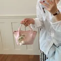 Trendige elegante rosa Mini-Leder-Eimertasche mit Perlen-Tulpen-Anhänger in der Hand - Mit Anhänger-Stil / Rosa