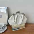 Elegant cream-white pleated handbag with silver ball clasp and knotted handle detail - White