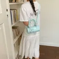 Light blue woven barrel crossbody bag for women featured in a stylish lifestyle setting - Green