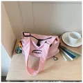 Close-up detail of a pink checkered canvas crossbody bag for summer casual fashion - With Charm / Pink