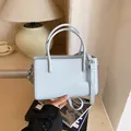 Elegante lichtblauwe handtas met handvaten en verstelbare riem voor woon-werkverkeer. - Blauw