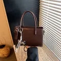 Elegant dark brown rectangular handbag for women with chic rope keychain charm - Coffee with Charm