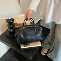 Black pebble leather Boston bag with braided edges and spherical charms - Black