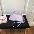 Minimalistische lavendelfarbene quadratische Handtasche mit Knotengriff und Metalldrehverschluss. - Lila
