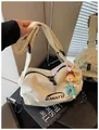 Modern cream canvas crossbody bag featuring BANATU branding and a charming cartoon keychain - With Charm / White