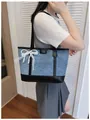 Stylish blue denim tote bag with black trim, shiny sequins, and pearl lace bow detail. - With Charm / Black