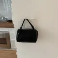 Elegant black cylinder pillow handbag for women in a minimalist lifestyle setting - Standard Type / Black