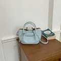 Elegant light blue leather bucket bag with knotted drawstring and silver hardware accents. - Blue