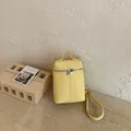 Trendy minimalist yellow crossbody bucket phone bag with matte finish and silver zippers - Yellow