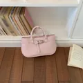 Elegant pink textured leather handbag with decorative buckle strap and top handles for women - Pink