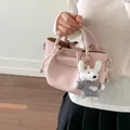 Elegant pink pebbled leather bucket bag for women featuring a cute white bunny keychain - Pink With Pendant