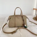 Spacious khaki canvas crossbody bag with brown faux leather trim and beaded charm detail - With Pendant / Khaki