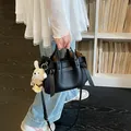 Élégant sac cabas noir en cuir texturé avec poignées et une bandoulière réglable - Noir Avec Pendentif / Noir