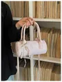 Close-up view of a pink cylinder handbag with delicate pearl and lace bow decorations - Pink (With Pearl Lace Pendant) / Pink