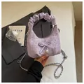 Détail de la poignée plissée et du pendentif nœud en perle sur ce sac en tweed lilas - Violet
