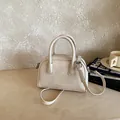 Elegant beige pillow bag with top handles and adjustable shoulder strap - White