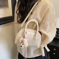 Elegant beige crossbody pillow bag for women featuring a cute plush bear charm and handle. - With Charm / White