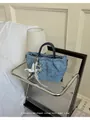 Elegant vintage blue denim women's handbag with star charm displayed on a glass side table - M / Dark Blue
