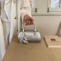 Trendy silver metallic pillow handbag with decorative bow charm and handle for women - With Charm / Silver