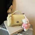 Stylish pale yellow vintage pebbled leather crossbody bag with a cute pink bear plush charm - With Pendant / Yellow