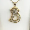 Detail shot of a gold-plated initial D necklace featuring a stone-set crown design - Letter D / Gold