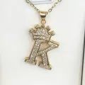 Close-up of gold-plated crown-topped letter R pendant necklace with sparkling cubic zirconia - Letter K / Gold