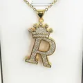 Detailed macro view of a gold-plated crown initial R pendant encrusted with clear zircons - Letter R / Gold