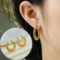 Detailed view showing elegant 18K gold plated stainless steel hoop earrings on model ear - Classic Round Hoop Style (783)