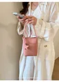 Detailansicht einer stilvollen rosa strukturierten Mini-Beuteltasche mit Sternenanhänger. - Rosa