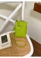 Nahaufnahme einer lindgrünen minimalistischen Handytasche mit Sternanhänger auf einem Stuhl - Grün