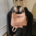Elegant pink pebbled leather bucket bag featuring top handle and crossbody strap - No Pendant / Pink