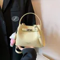 Light yellow pebbled leather bucket bag with top handle and plush charm - With Pendant / Yellow