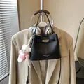 Elegant black leather bucket handbag with turn-lock closure and white bear charm - With Pendant / Black