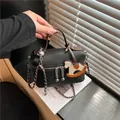 Elegante schwarze Handtasche aus genarbtem Leder mit Metallkette und Pferdeanhänger - Stil mit Anhänger / Schwarz