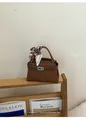 Κομψή καφέ μικρή τετράγωνη τσάντα με εμπριμέ μαντήλι σε ξύλινο ράφι, ρετρό αισθητική - Καφέ