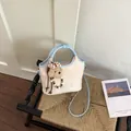 Sac seau bandoulière beige et bleu clair chic avec breloque ours sur une chaise - Bleu Avec Pendentif