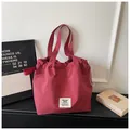 Close-up of large maroon grid canvas tote bag with drawstring detail and brand patch - No Pendant / Red