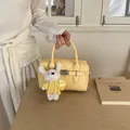 Elegant yellow lychee leather bowling bag featuring a cute white plush rabbit charm - With Pendant / Yellow