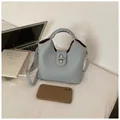 Elegante hellblaue Eimertasche aus geprägtem Leder mit silbernem Drehverschluss und Gurt - Reguläre Passform / Blau