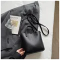 Elegant black pebbled leather bucket bag featuring a top handle and shoulder strap - Black without Pendant