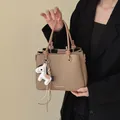 Sophisticated khaki bucket bag featuring top handle design and decorative horse charm - With Pendant / Khaki