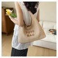 Close-up detail of hand-woven straw tote bag featuring TOTE BAG embroidery for summer - Style 1 (Letter Embroidery) / Brown