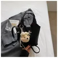 Detailed view of a black litchi pattern handbag with cute bear keychain accessory - With Pendant / Black