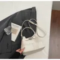 Elegante cremefarbene Eimertasche für Damen mit silbernen Beschlägen und Gurt - Ohne Anhänger / Gebrochenes Weiß