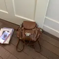 Sweet brown faux leather backpack with silver bow accent for school and everyday travel use. - Brown