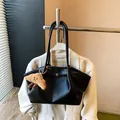 Elegante borsa tote in pelle martellata nera con design minimalista e ciondolo peluche - Con Ciondolo / Nero