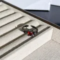 Makroaufnahme eines gotischen schwarzen Rings mit rotem Herzstein und Fledermausflügeln. - Fledermausflügel Herz Offener Ring