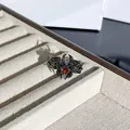 Primer plano de un anillo de araña negra gótica con una piedra roja en forma de lágrima - Anillo Abierto Araña Espinas Gema Roja