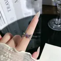 Nahaufnahme eines silbernen Schmetterlingsrings mit lila Kristallen und Kettenquasten. - Lila Schmetterling Quastenkette Stil (4)
